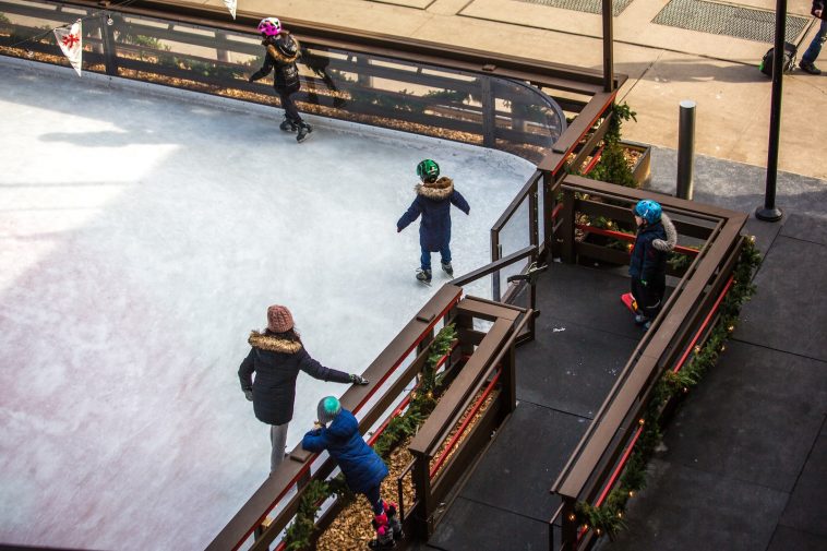 three children skating on ice rink