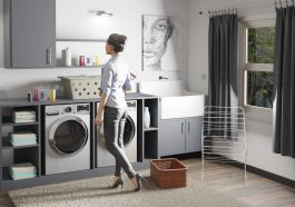 a woman standing in a laundry room next to a washer and dryer