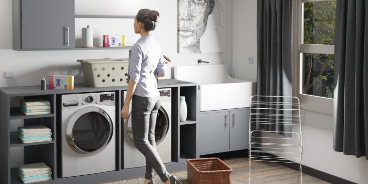 a woman standing in a laundry room next to a washer and dryer