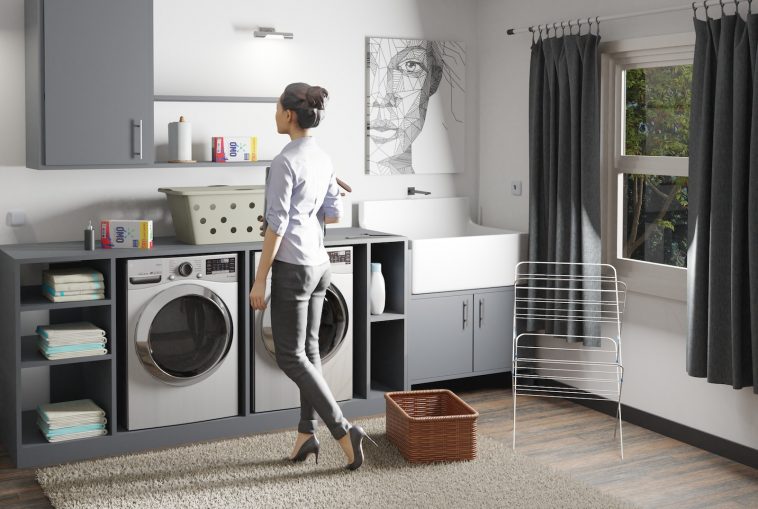 a woman standing in a laundry room next to a washer and dryer