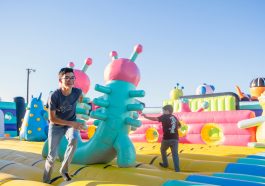 a man standing next to a giant inflatable alien