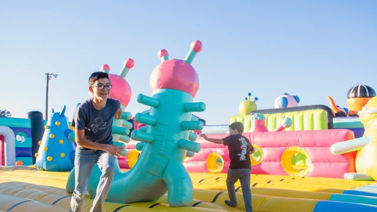 a man standing next to a giant inflatable alien
