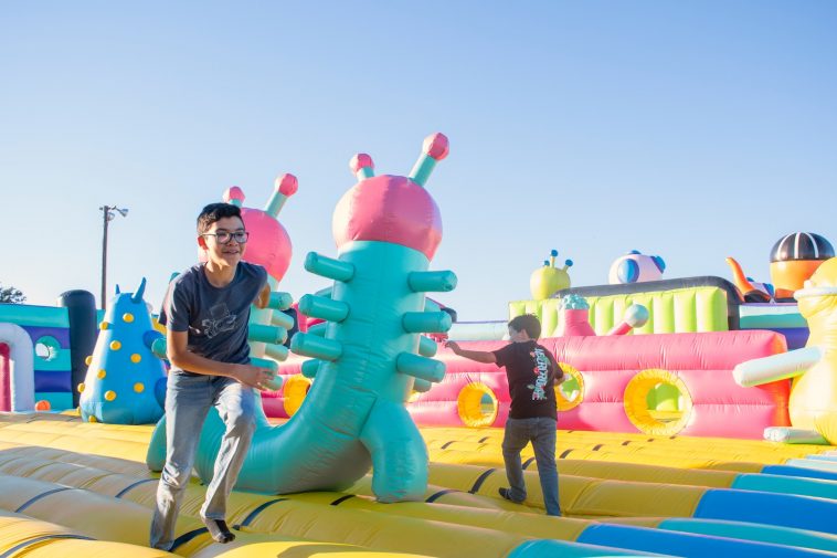 a man standing next to a giant inflatable alien