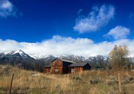 a small wooden house in a field