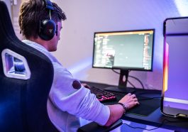 a man wearing headphones sitting in front of a computer