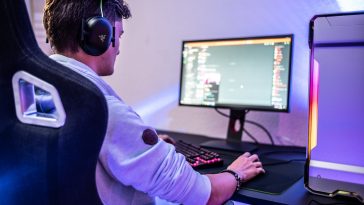a man wearing headphones sitting in front of a computer