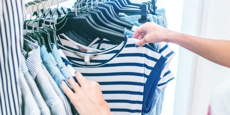person holding white and black striped shirt