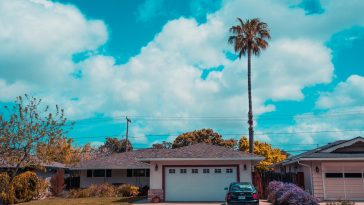 white and gray house with closed garage door