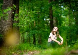 woman in white shirt standing on green grass field during daytime