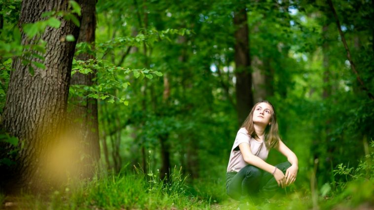 woman in white shirt standing on green grass field during daytime