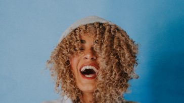 smiling woman wearing gray hoodie