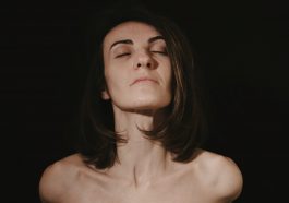 a woman with her eyes closed in the dark