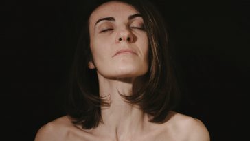 a woman with her eyes closed in the dark