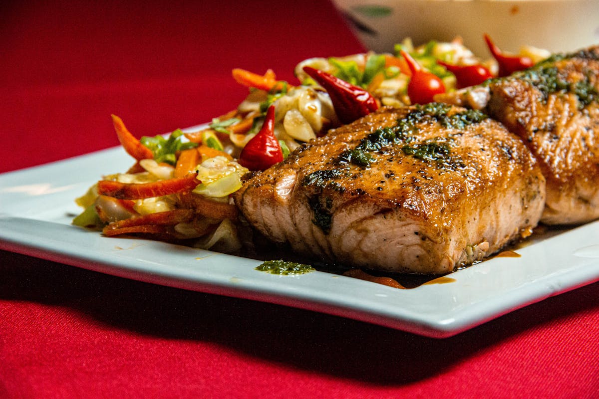 Grilled salmon fillet served with a colorful vegetable medley